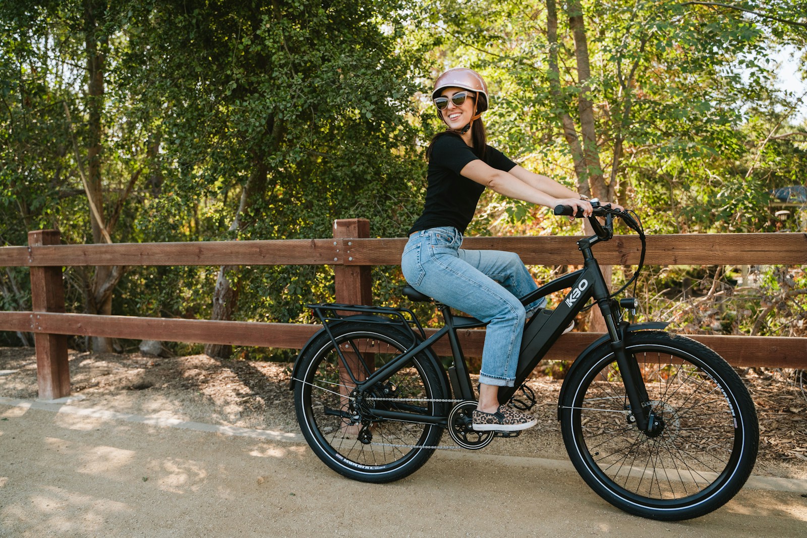 a woman in black shirt riding a black bike